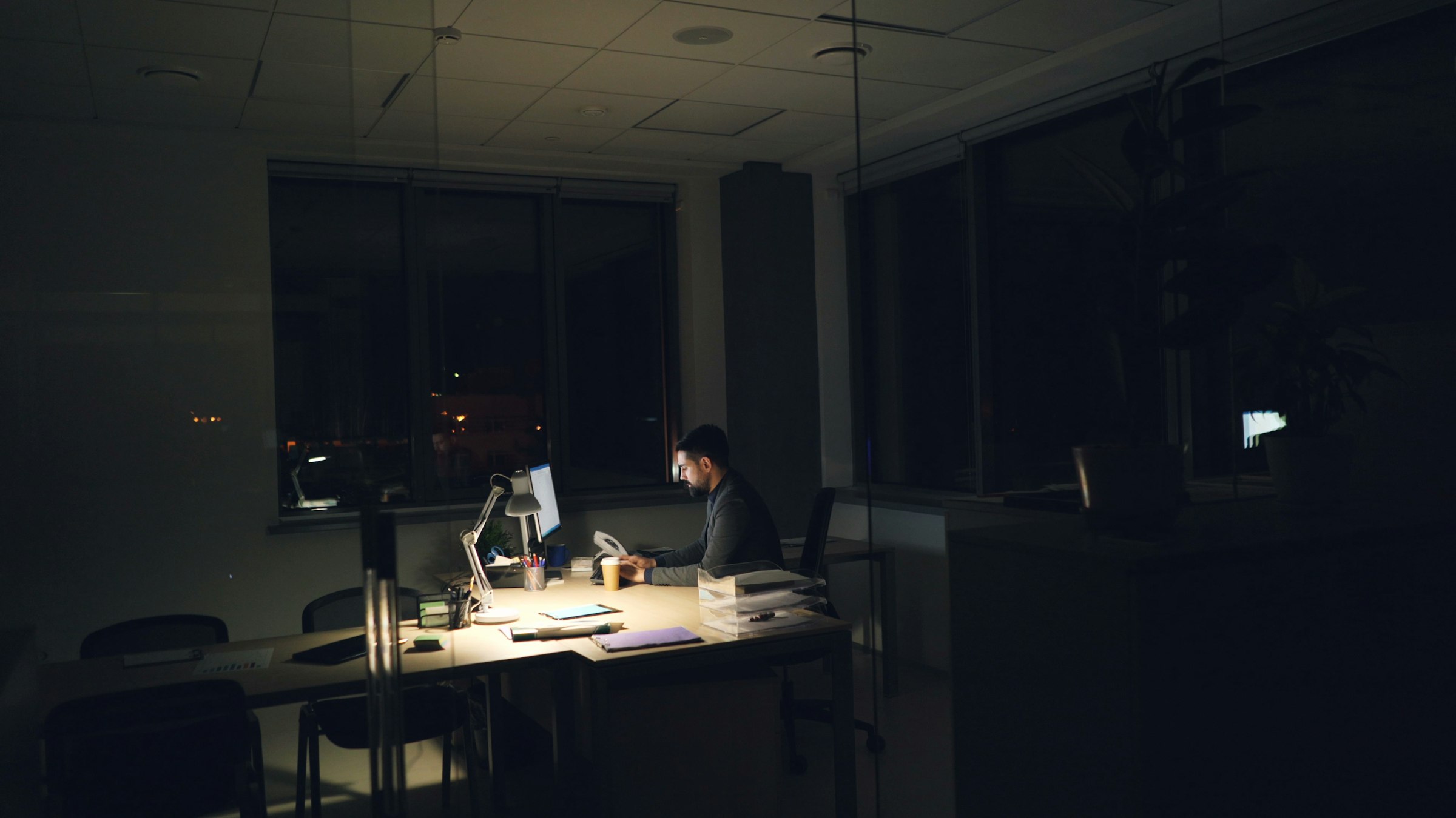 Analyst reviewing contract documents at night